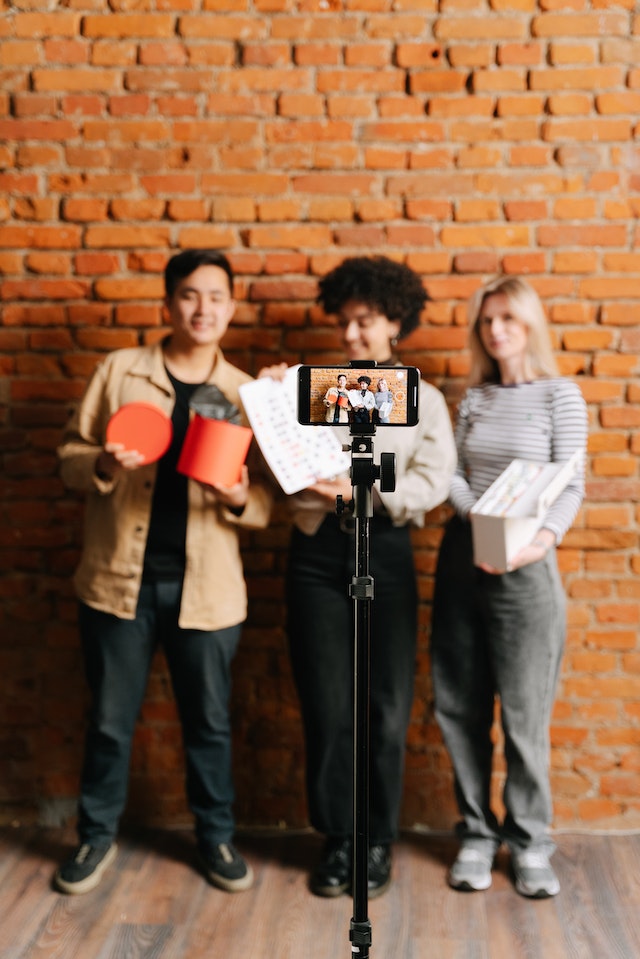 Um grupo de pé e gravando um TikTok juntos.