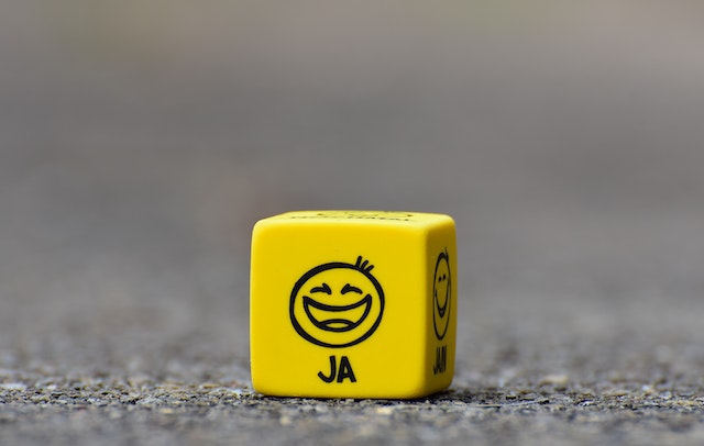 幸せの絵文字が描かれた黄色いキューブが床に置かれている。