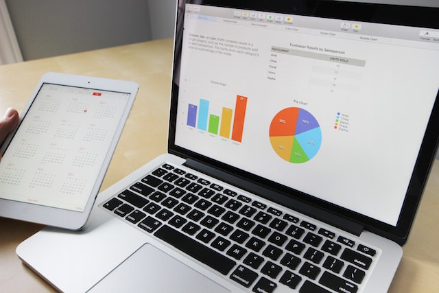 Un computer portatile e un iPad che mostrano grafici e diagrammi aziendali.