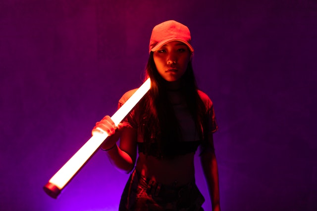 A woman in a red cap holding a white fluorescent. 
