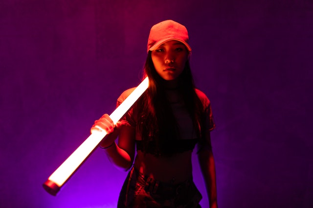 Uma mulher com um boné vermelho segurando uma fluorescente branca. 