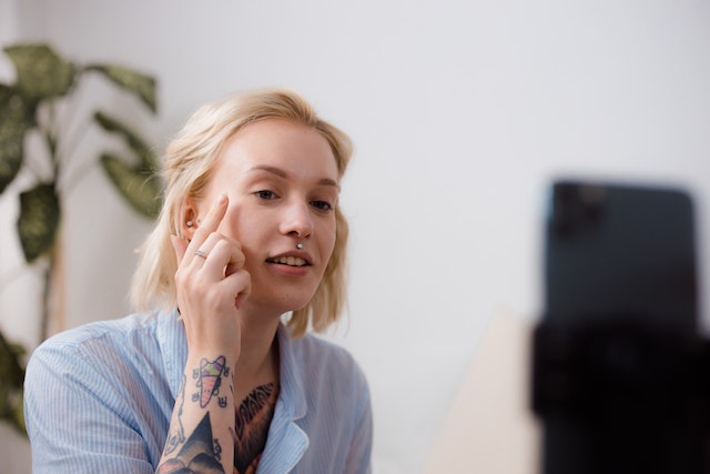 Uma garota gravando um tutorial de maquiagem para um vídeo do TikTok.