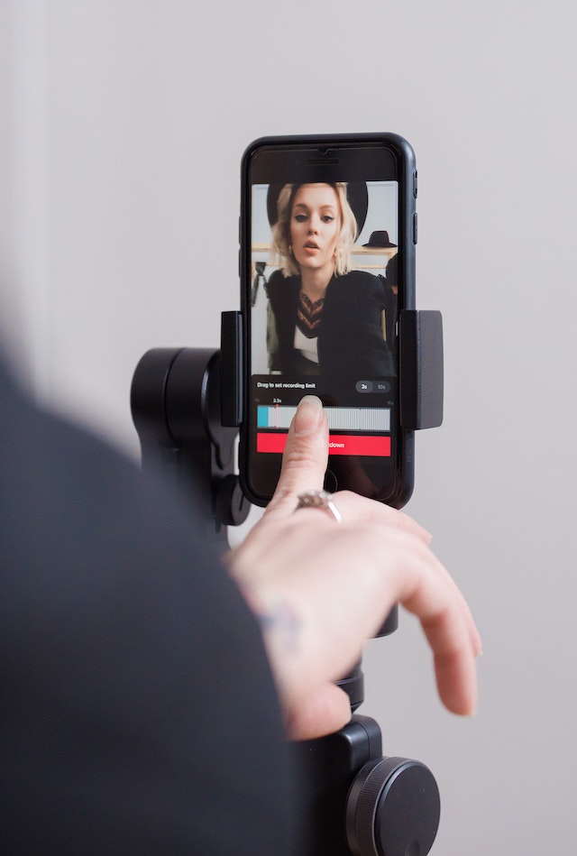 A girl recording a TikTok video on her smartphone.