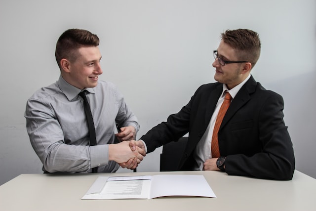 Twee professionals die elkaar de hand schudden.