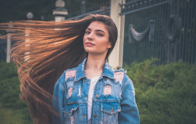 Donna che si scompiglia i lunghi capelli per una foto. 