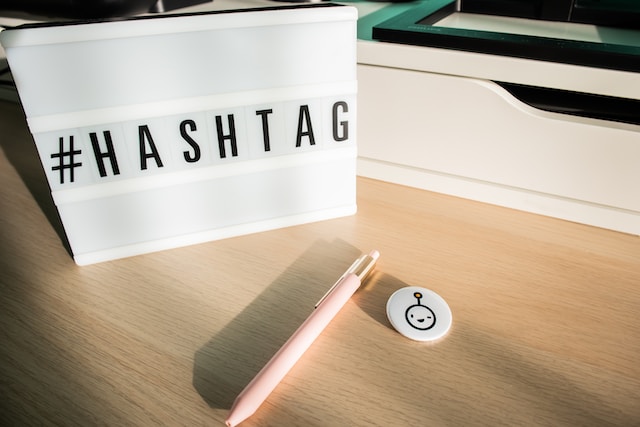 A white tile with the hashtag symbol in front of letter tiles spelling the word “Hashtag.”