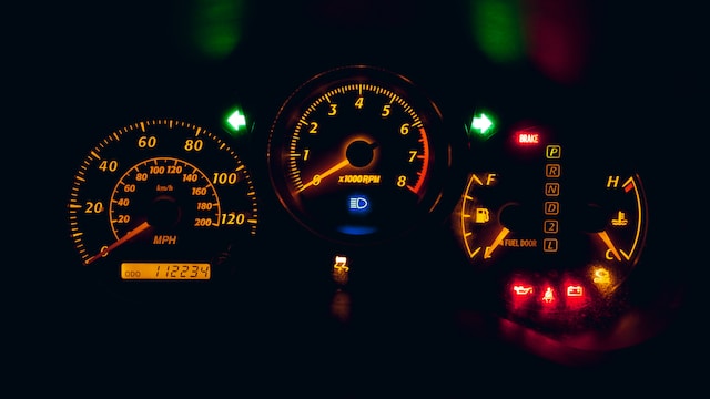 Black and yellow analog speedometer. 