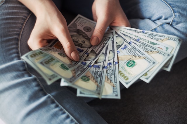 A person counting hundred-dollar bills. 