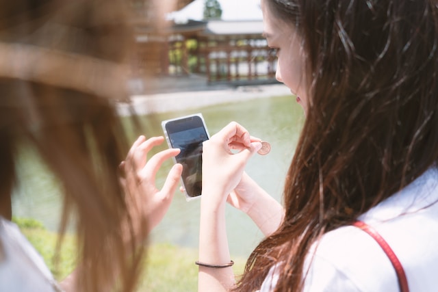 Twee dames bekijken een foto op een smartphone.