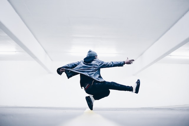 Een man in een blauw shirt danst.