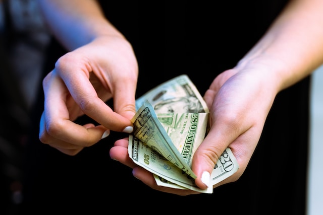 A person counting money to make a payment.