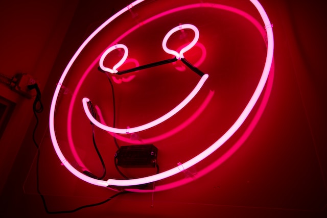 A neon sign in the shape of a smiley face.