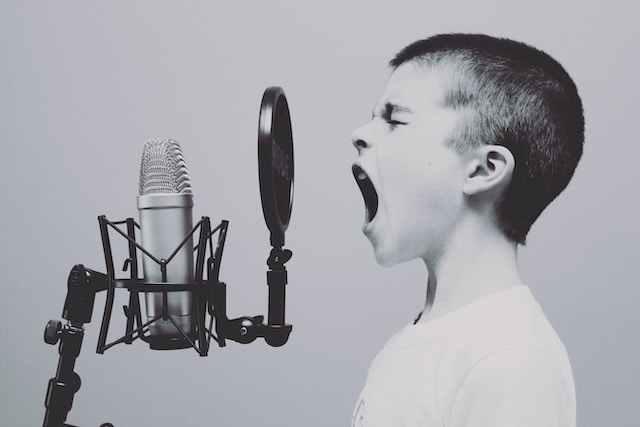 A boy screaming into a microphone.