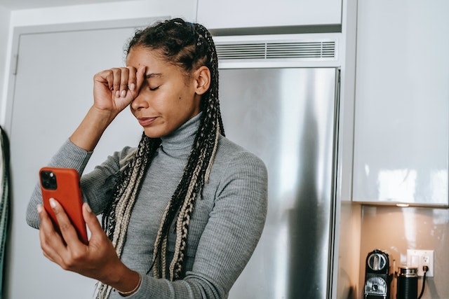 Une jeune femme frustrée parce qu'elle ne peut pas suivre les gens sur TikTok.