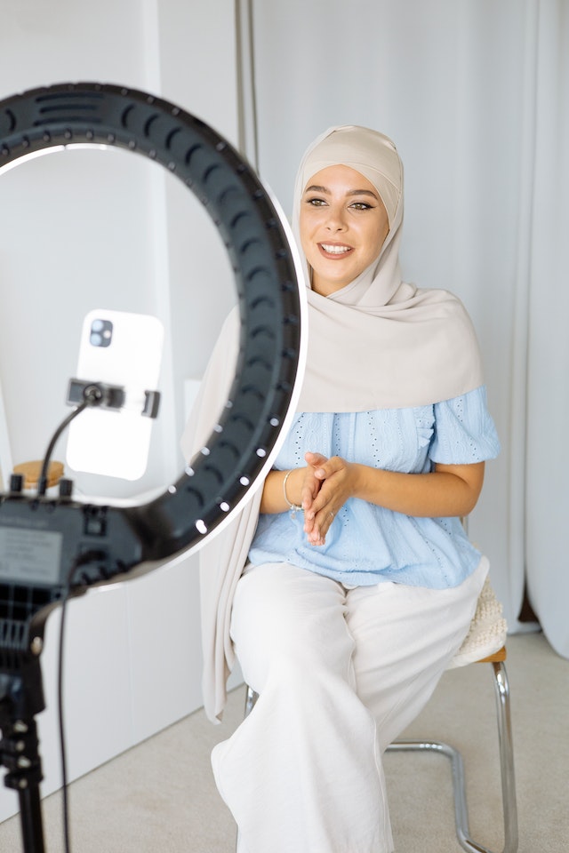 Una donna in hijab che si registra per un video su TikTok. 