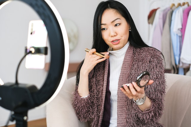 A woman applying makeover before her TikTok live session.