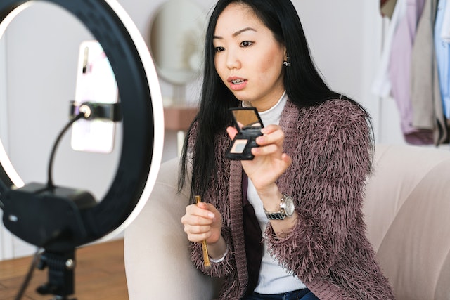 An influencer recording a video on makeup and beauty tips.