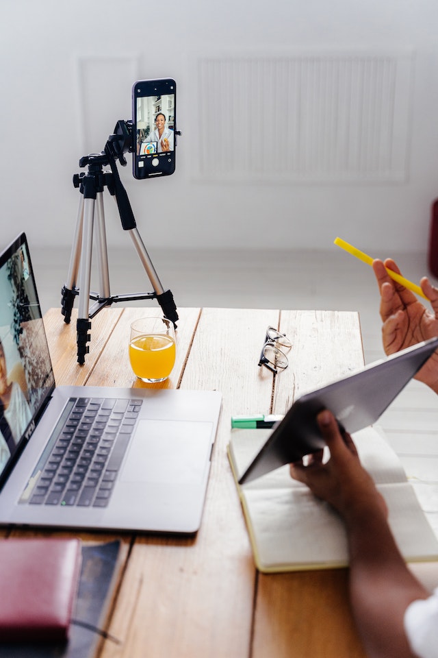 Een persoon die een digitale tablet vasthoudt en zichzelf opneemt voor TikTok. 