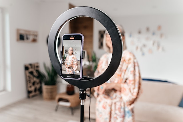 A woman recording a video of herself for TikTok. 