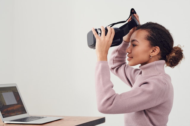 Una chica con gafas de realidad virtual y jugando. 