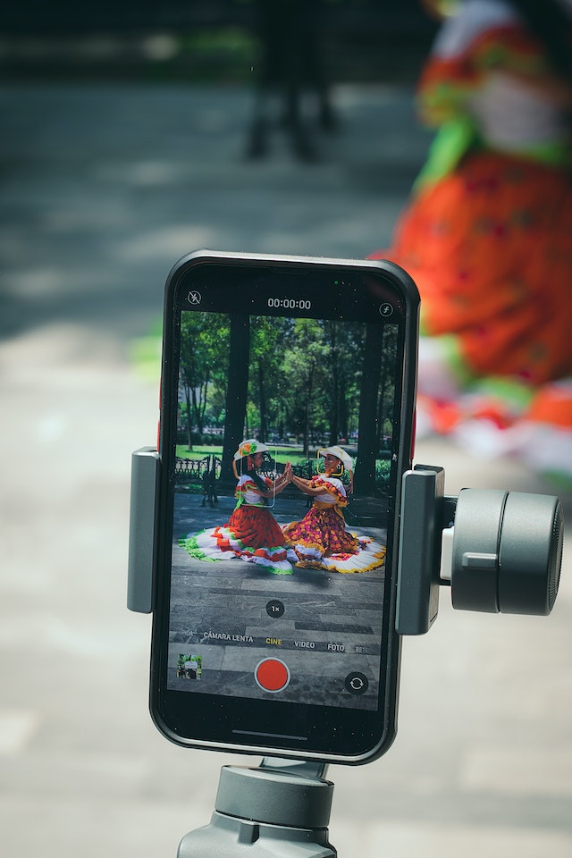 2 women dancing in costumes and recording a video for TikTok.