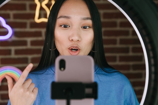 An influencer recording a TikTok of herself.