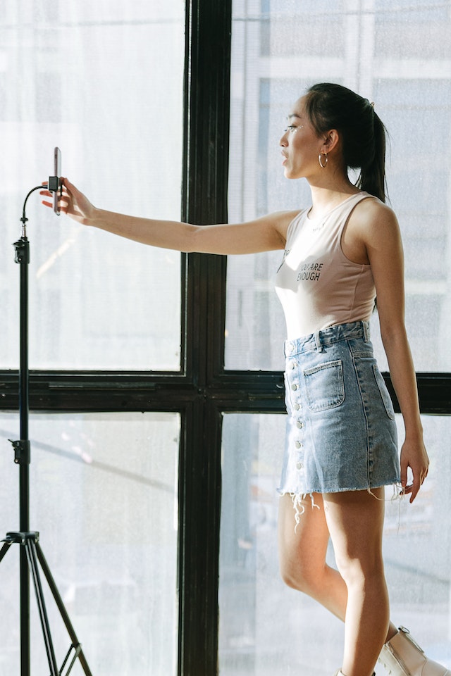 A girl recording a TikTok video of herself. 