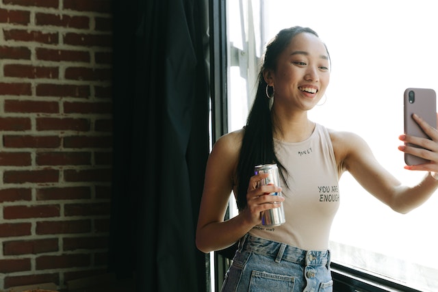 A girl holding a smartphone and recording a TikTok.