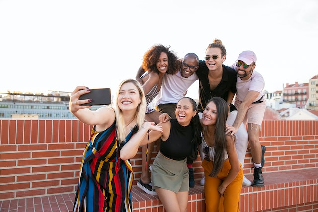 Un gruppo di persone che si scatta un selfie all'aperto per i social media.