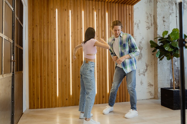 A man and a woman dancing together to create a TikTok video.