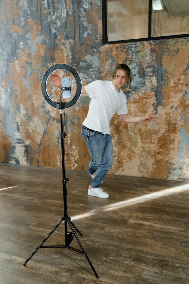 Um homem dançando e gravando um vídeo para o TikTok.