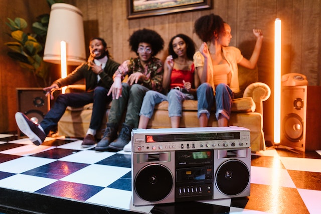 A group of people listening to music from a cassette player.