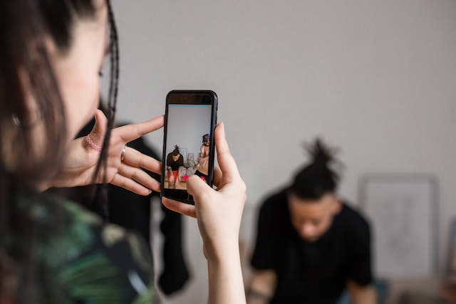 Une jeune fille enregistre une vidéo d'un groupe en train de danser pour une vidéo TikTok.