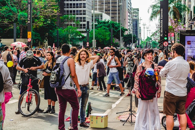 Uma multidão parada na rua.