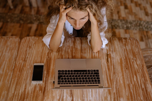 A lady thinking of how to edit captions on TikTok before posting.