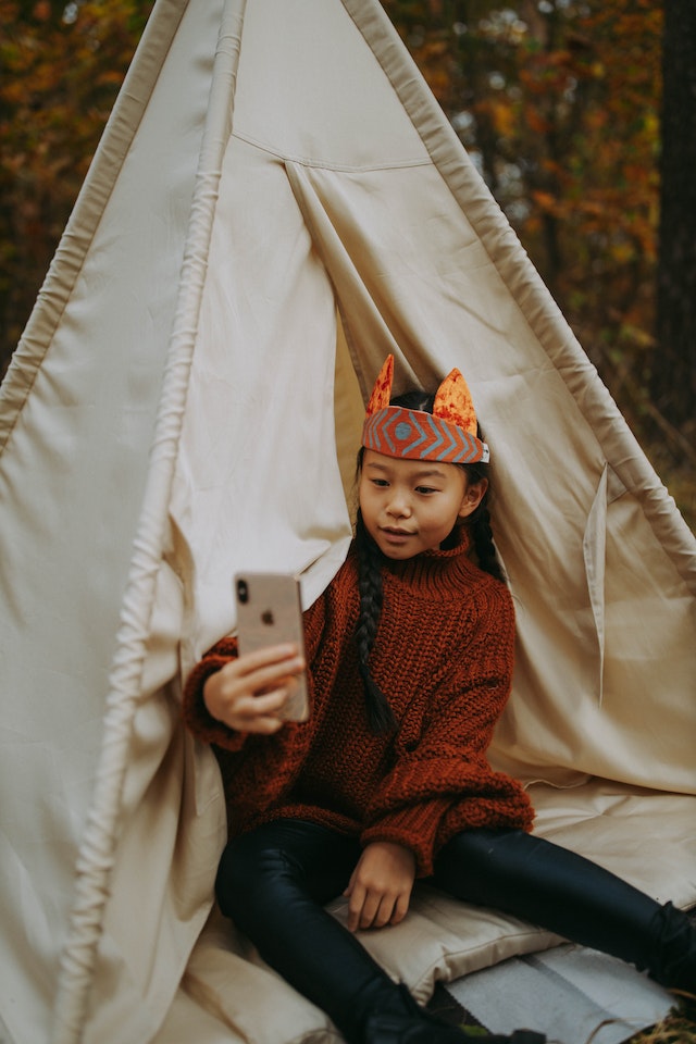 할로윈 의상을 입은 소녀가 틱톡을 녹화하고 있습니다.