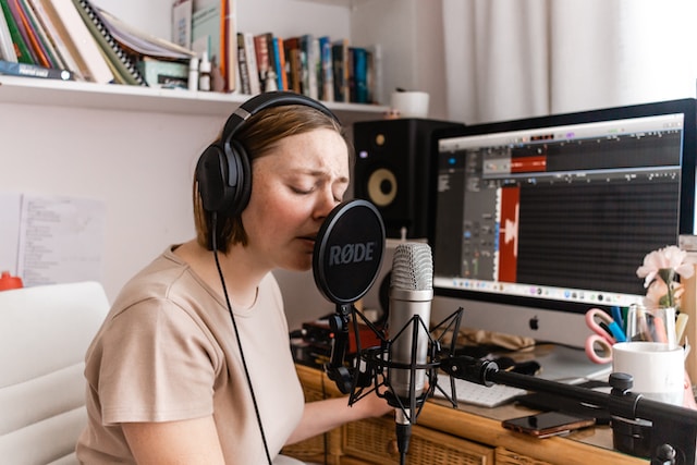 A woman recording herself while singing.