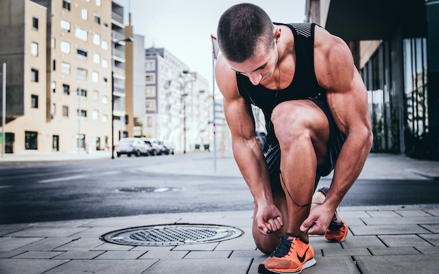 A runner tying his shoes.