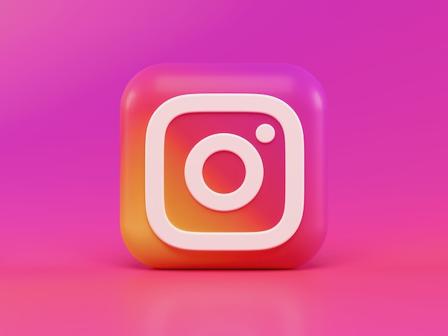 A pink and orange cube with a white camera Instagram logo.