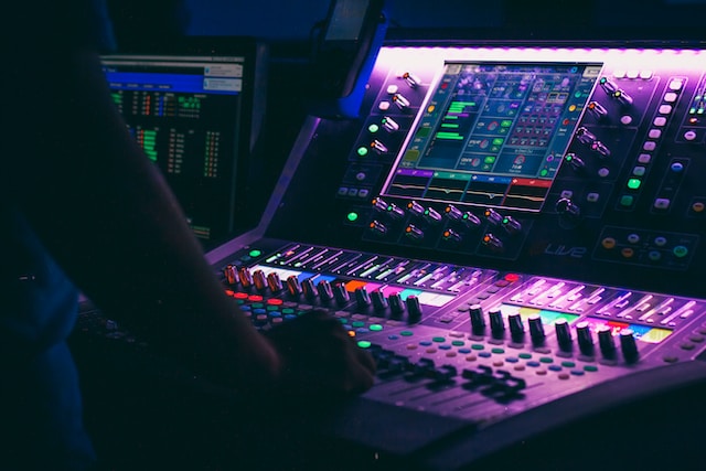 A person controlling an audio mixer.