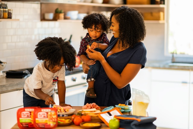 A mom preparing food for her two kids.