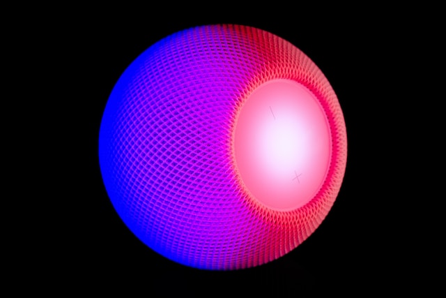 A round, purple and blue wireless speaker.