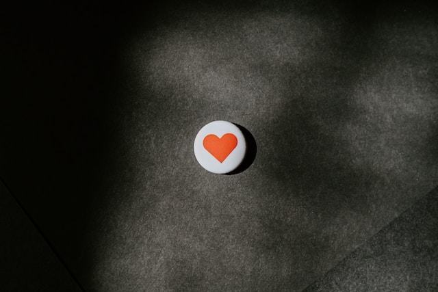 A red heart painted on a white circle.