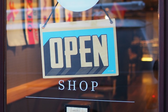 Un panneau "Open" accroché à une porte vitrée.