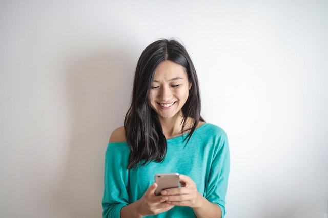 Una señora sonríe feliz por el número de likes que tiene su vídeo.