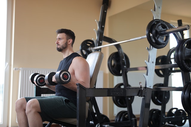 A fitness influencer using dumbbells in the gym.