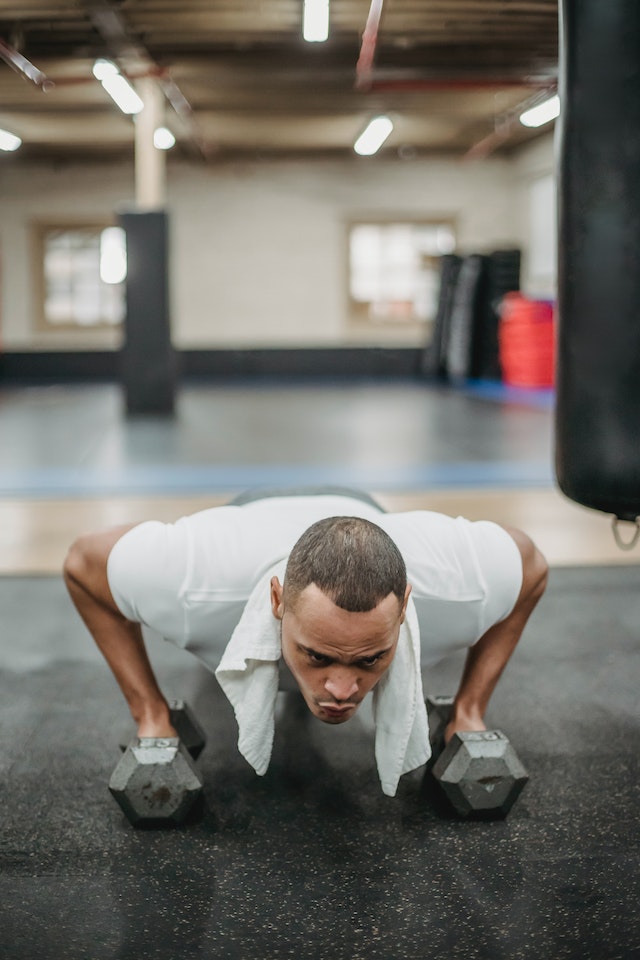 Een fitness influencer doet planken in de sportschool.