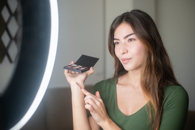 Une influenceuse maquillage créant une vidéo TikTok.