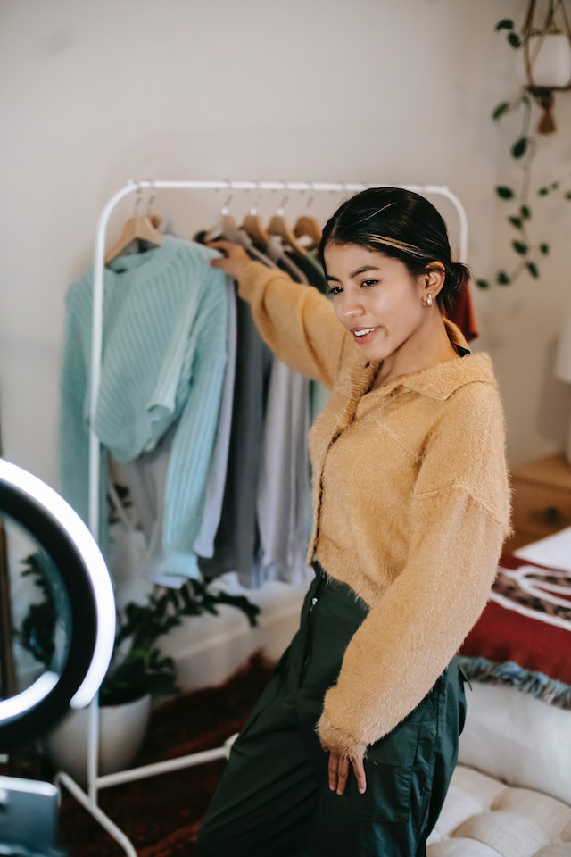 A fashion influencer showing different clothes for a TikTok video.