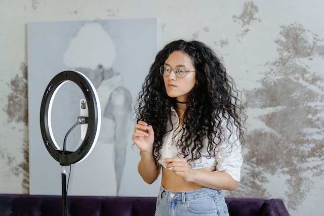 A girl influencer in a white shirt doing a live stream on TikTok.